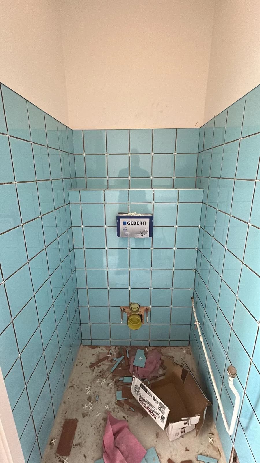 Toilet tijdens het betegelen, inbouwreservoir nog zichtbaar