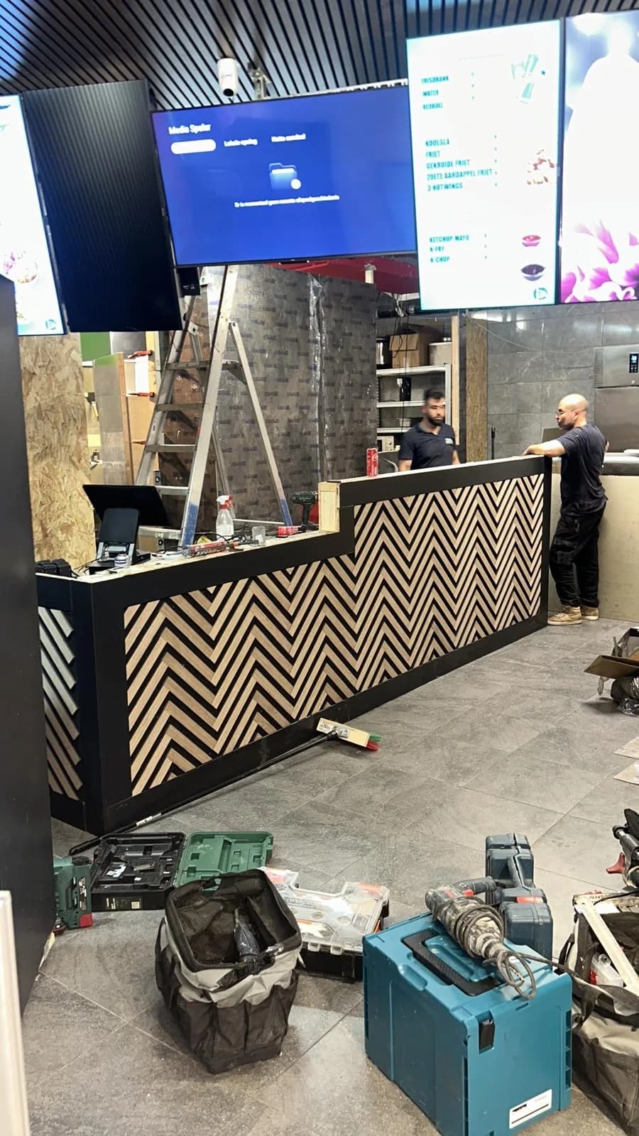 Bar in aanbouw in een horecazaak, twee vakmensen aan het werk