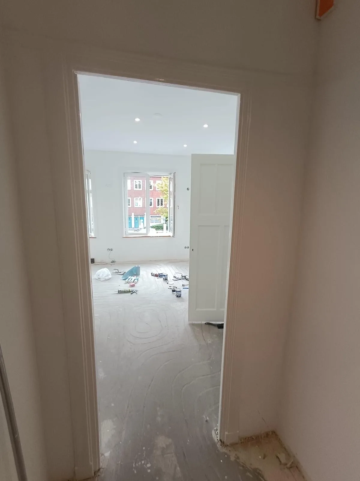 Strak afgewerkte kamer met witte wanden na de renovatie